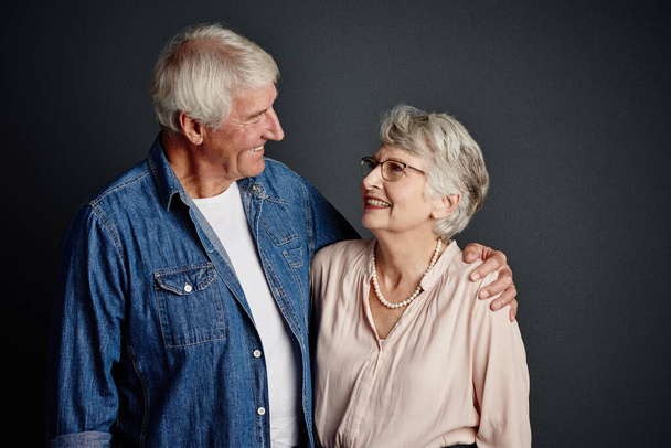Ich werde immer an Ihrer Seite sein. Studioaufnahme eines liebevollen Seniorenpaares, das vor grauem Hintergrund posiert - Foto, Bild