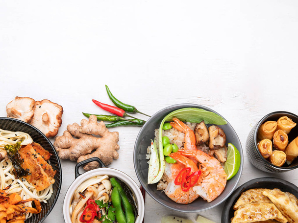 Assorted Chinese food set. Chinese noodles, fried rice, dumplings, peking duck, dim sum, spring rolls. Famous Chinese cuisine dishes on a white background. Top view. Chinese restaurant concept. Asian style banquet. Copy space. - Foto, Imagem