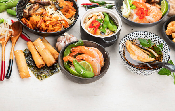 Assorted Chinese food set. Chinese noodles, fried rice, dumplings, peking duck, dim sum, spring rolls. Famous Chinese cuisine dishes on a white background. Top view. Chinese restaurant concept. Asian style banquet. Copy space. - Фото, изображение