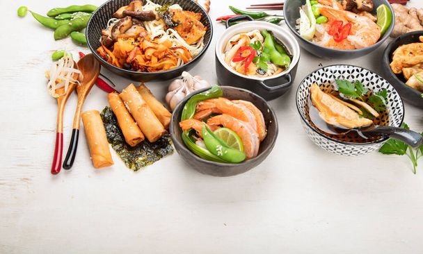 Assorted Chinese food set. Chinese noodles, fried rice, dumplings, peking duck, dim sum, spring rolls. Famous Chinese cuisine dishes on a white background. Top view. Chinese restaurant concept. Asian style banquet. - Photo, image