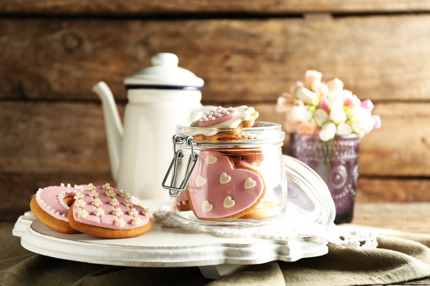 Печенье в форме сердца на День Святого Валентина и чайник на деревянном фоне
 - Фото, изображение