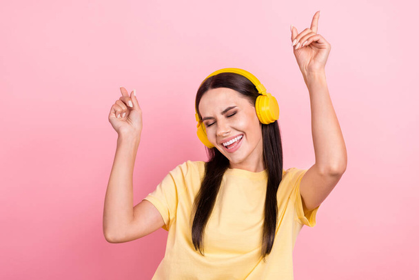 Photo of cute sweet lady wear yellow t-shirt earphones dancing having fun isolated pink color background. - Фото, изображение