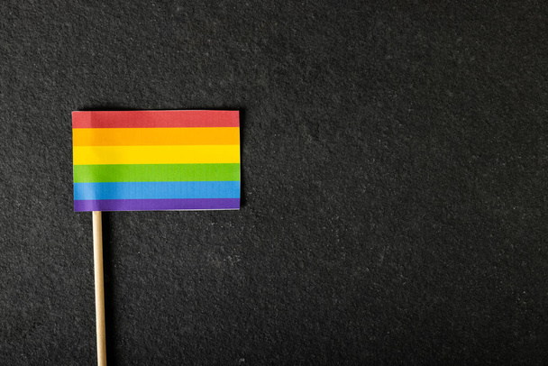Overhead view of rainbow flag isolated against black table, copy space. Unaltered, lgbtqia rights, freedom, equality and pride concept. - Fotó, kép