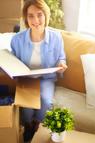 Young woman moving out and packing cardboard box. - 写真・画像