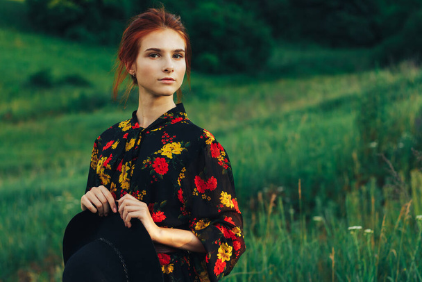 portrait of a beautiful girl with brown hair among the flowers in the field. summer holiday with flowers. - Fotó, kép