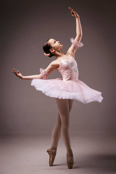 Bailarina. Joven bailarina de ballet adolescente elegante, vestida con traje profesional, zapatos de ballet y falda rosa Tutu. Hermosa adolescente de danza clásica de ballet - Foto, imagen