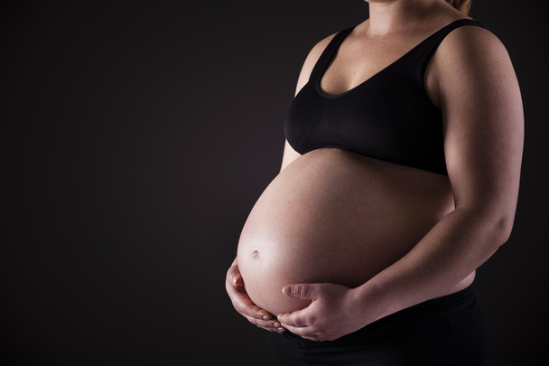 Pregnant woman holding his belly - Fotoğraf, Görsel