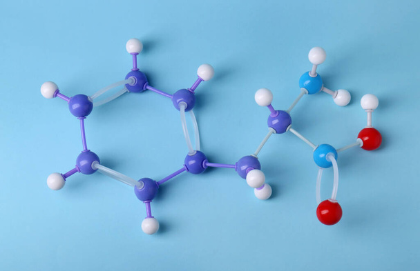 Molecule of phenylalanine on light blue background, top view. Chemical model - Foto, imagen
