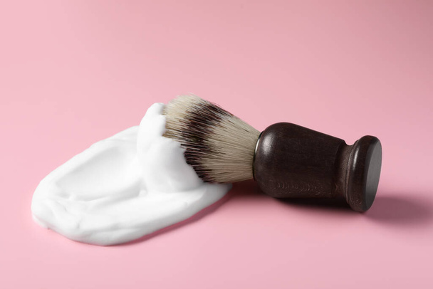 Brush with shaving foam on pink background, closeup - Фото, изображение
