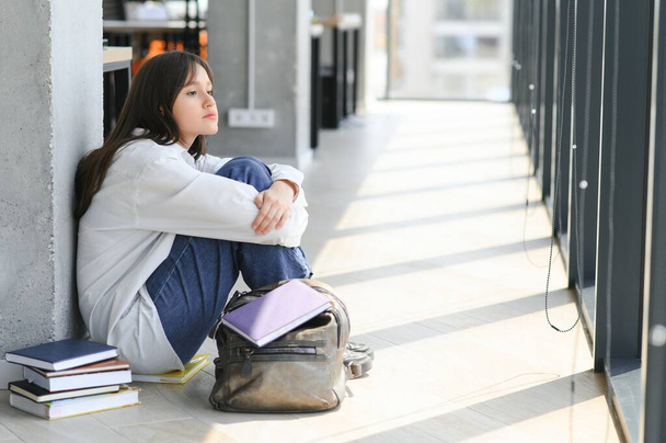 Asian young girl student sitting alone with sad feeling at school. - Φωτογραφία, εικόνα