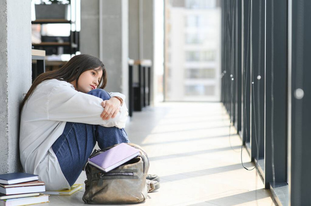 Asian young girl student sitting alone with sad feeling at school. - Foto, afbeelding