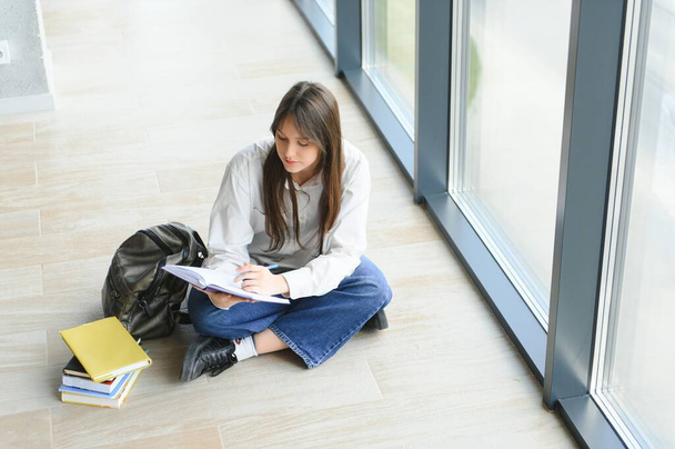 education and school concept - student girl studying and reading book at school - Foto, Imagem