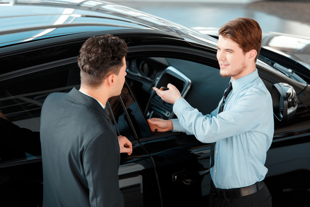 Car salesman talking to a customer - Фото, зображення