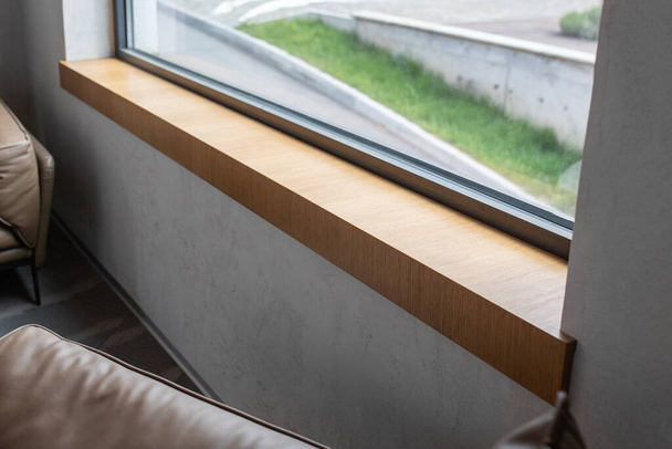Wooden window sill near a large window in a modern interior. - Photo, Image