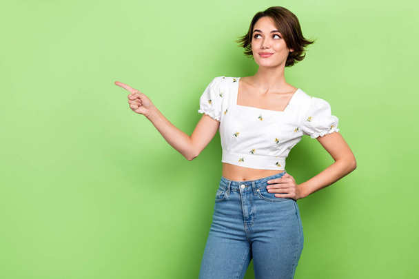 Photo of adorable nice lady model advise product commercial billboard poster wear crop shirt jeans isolated green color background. - Fotó, kép