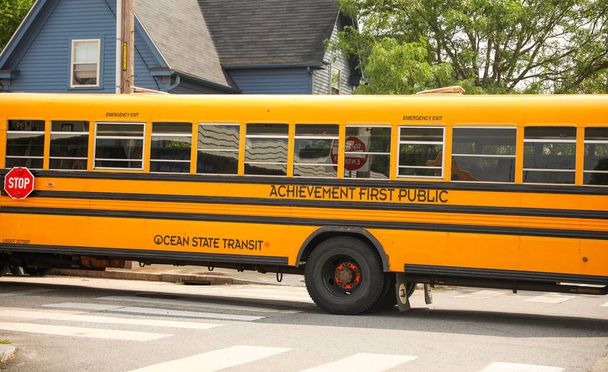 żółty autobus szkolny zaparkowany na tle śmiechu dzieci, symbolizujący edukację, społeczność i podróż wiedzy - Zdjęcie, obraz