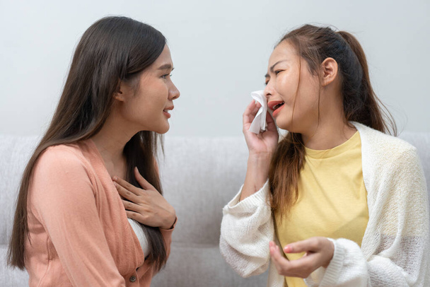 Two women talking about problems at home. Asian women embrace to calm their sad best friends from feeling down. Female friends supporting each other. Problems, friendship, and care concept - Фото, зображення
