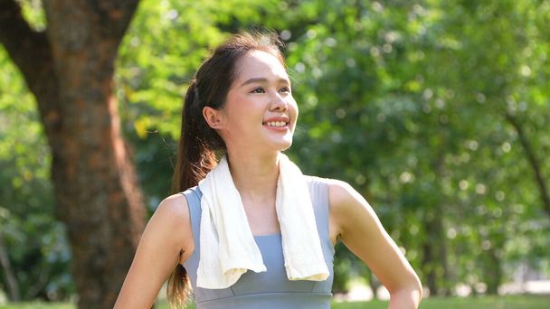 Portrait young asian woman attractive smiling and use white towel resting after workout. Smiling sporty young woman working out outdoors and looking at camera. Healthy lifestyle well being wellness - Foto, Imagen