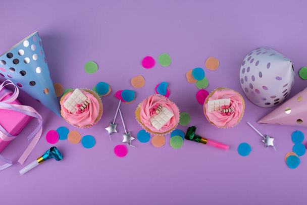 Concetto di sfilata di compleanno con cupcake, coriandoli e ghirlanda - Foto, immagini