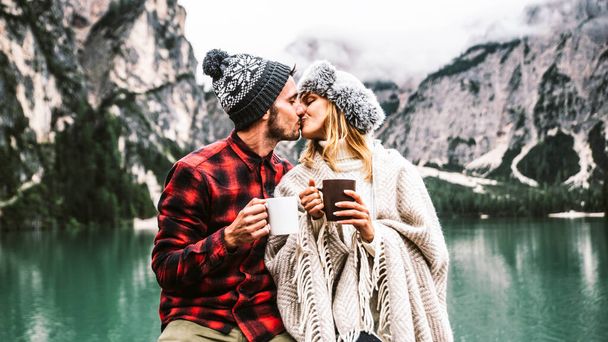 Bries Italyの高山湖を訪れる大人のカップルのロマンチックなキス。秋の山々で一緒に愛する瞬間を過ごす愛の観光客。夫婦、放浪欲と旅行の概念. - 写真・画像