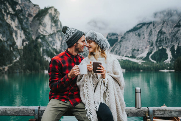 Romantyczny pocałunek pary dorosłych odwiedzających alpejskie jezioro w Braies Italy. Turysta zakochany spędza razem miłe chwile w jesiennych górach. Pojęcie pary, wędrowania i podróży. - Zdjęcie, obraz