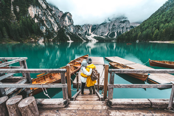 Hikers visiting italian alpine Braies Lake - Couple in love enjoying stunning view of Lago di Braies in Dolomites, South Tyrol, Italy, Europe. - Photo, Image