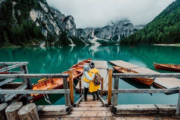 Hikers visiting italian alpine Braies Lake - Couple in love enjoying stunning view of Lago di Braies in Dolomites, South Tyrol, Italy, Europe. - Foto, Imagem