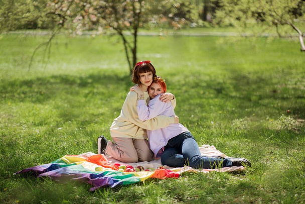 In the park lesbian two ladies have a picnic they eating fruits and enjoy the good weather concept of lgbt lifestyle. Lgtb - Foto, Bild