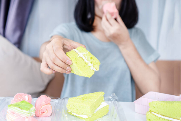 azúcar y dulces concepto de adicción con la mano de la mujer sobre comer muchos postres - Foto, imagen