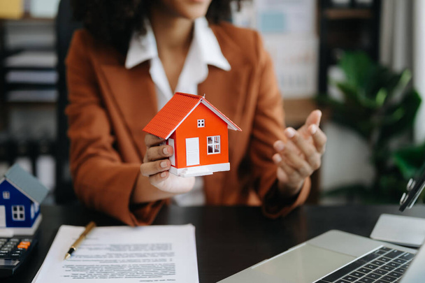 Considering buying a home, investing in real estate. female Broker signs a sales agreement. agent, lease agreement, successful deal in office - Fotó, kép