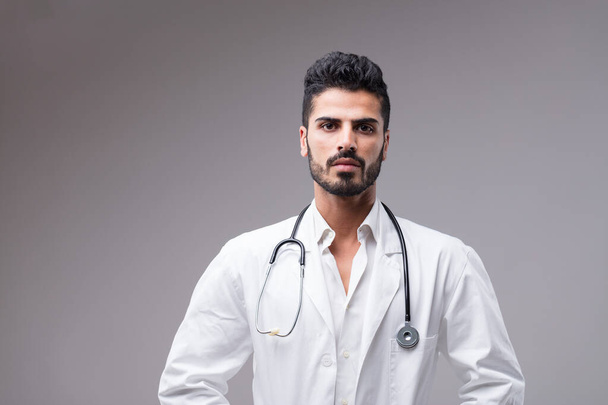 Vakava, tummaihoinen Lähi-idän lääkäri. Nuoren miehen muotokuva, ammattimaisesti hoidettu parta, valmiina auttamaan sinua - Valokuva, kuva