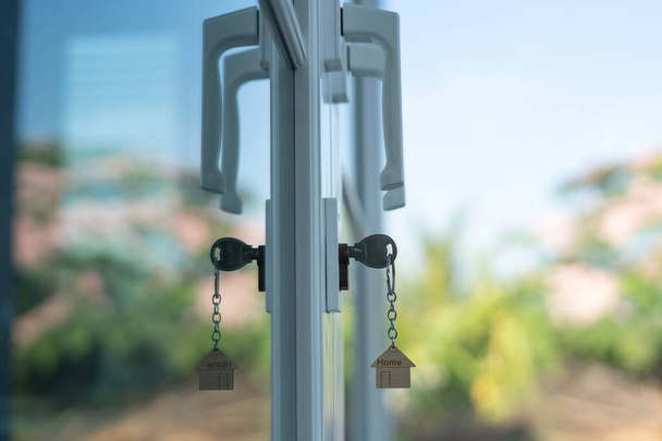 Landlord key for unlocking house is plugged into the door. Second hand house for rent and sale. keychain is blowing in the wind. mortgage for new home, buy, sell, renovate, investment, owner, estate - 写真・画像