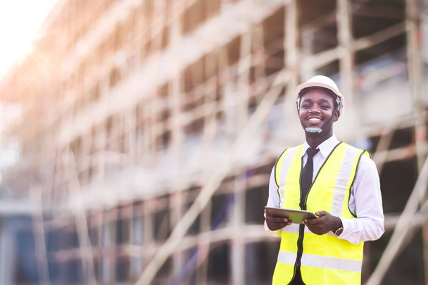 Afričtí architekti inženýr muž s tabletem pracují společně na staveništi stavby.Inženýrské koncepty a technologické aplikace - Fotografie, Obrázek