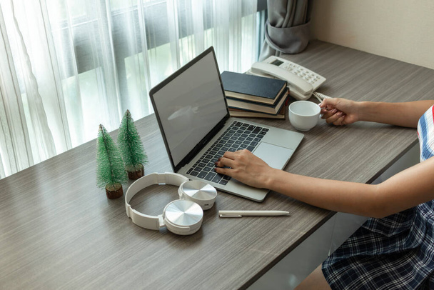 Young women work from home and use laptop computers to search for information and communicate with colleagues to work online. The concept of working from home with Notebook via online system. - Photo, Image