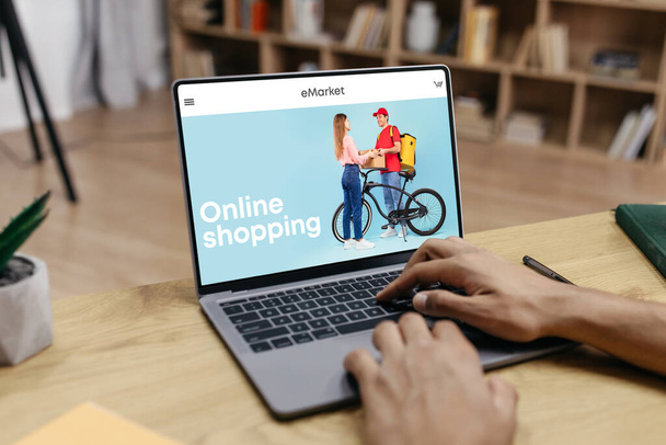 Schwarzer Mann mit Laptop für Online-Einkäufe, Kleiderkauf im Modegeschäft, Einkauf von zu Hause aus. Bestellung, Verkauf für Shopaholic, App und Website für neue Kleidung - Foto, Bild