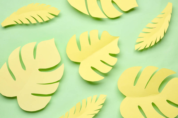 Papier jaune feuilles tropicales sur fond vert - Photo, image