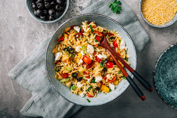 Homemade orzo pasta salad with feta, olives, tomatoes - 写真・画像