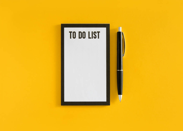 Bílý list se seznamem frází a černé pero na žlutém pozadí. stock fotografie - Fotografie, Obrázek