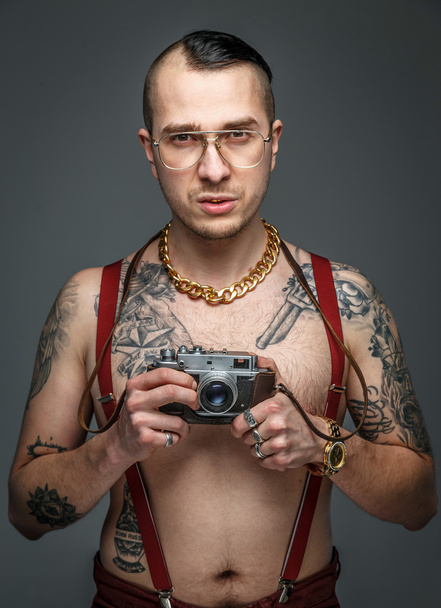 Tatuato uomo in possesso di fotocamera fotografica
 - Foto, immagini