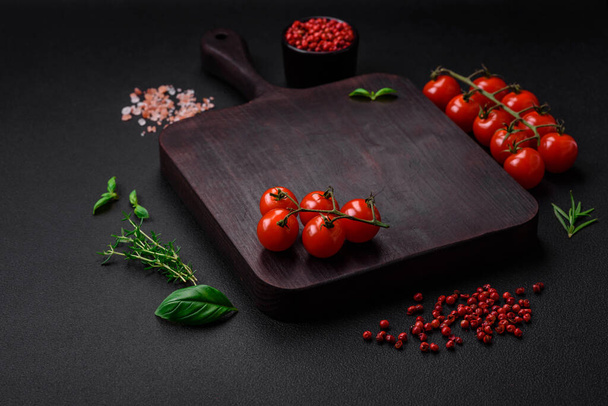 Ingredienti per la cottura di pomodorini, sale, spezie ed erbe su fondo di cemento scuro - Foto, immagini