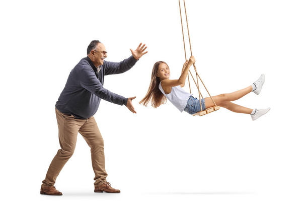 Grandfather pushing granddaughter on a swing isolated on white background - Foto, immagini