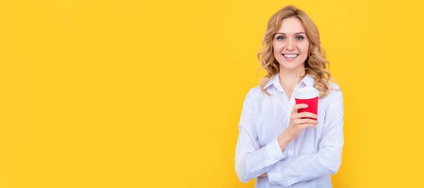 gelukkige blonde vrouw met koffie kopje in de ochtend op gele achtergrond. Vrouw geïsoleerd gezicht portret, banner met mock up kopieerruimte - Foto, afbeelding