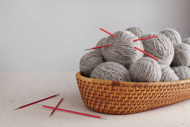 Double pointed knitting needles and balls of yarn in basket - 写真・画像