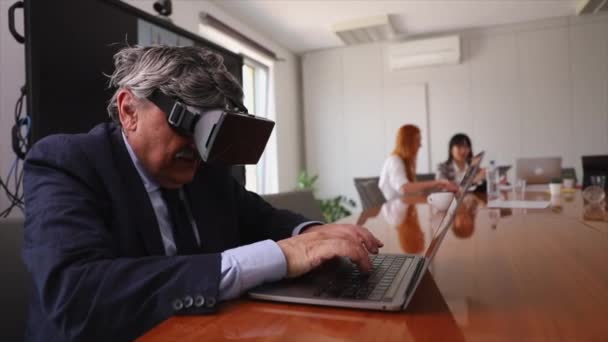 Бизнесмен работает с VR гарнитурами в офисе. Он счастлив и радуется - Кадры, видео