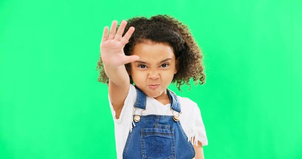 Angry child, stop and hand on green screen background with emoji and attitude. Black kid portrait in studio with space, mockup and sign for warning, power and protest to reject, defence or decline. - Photo, image
