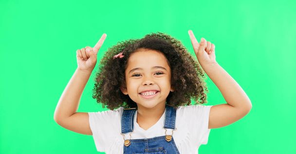 Mockup, green screen and child pointing up at product placement space isolated against a studio background. Excited, happy and portrait of young kid advertising and marketing showing deal or sale. - Foto, afbeelding
