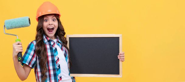 Überraschte Teenie-Mädchen halten Farbroller und Schultafel in der Hand. Kinderbauer im horizontalen Plakatdesign. Banner-Header, Kopierraum - Foto, Bild