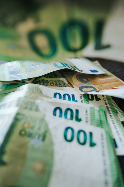 Honderd euro stapel op een zwarte tafel close-up. zachte focus.Europese Unie geld. Inkomsten en uitgaven in de eurozone. Salaris, uitkeringen en pensioenen in Europa. - Foto, afbeelding