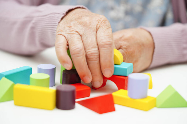 Asian elderly woman playing puzzles game to practice brain training for dementia prevention, Alzheimer disease. - 写真・画像