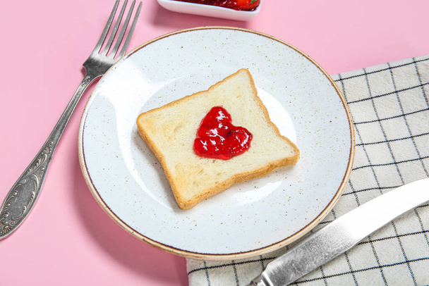 Plate with toast and sweet jam on pink background, closeup - Фото, изображение